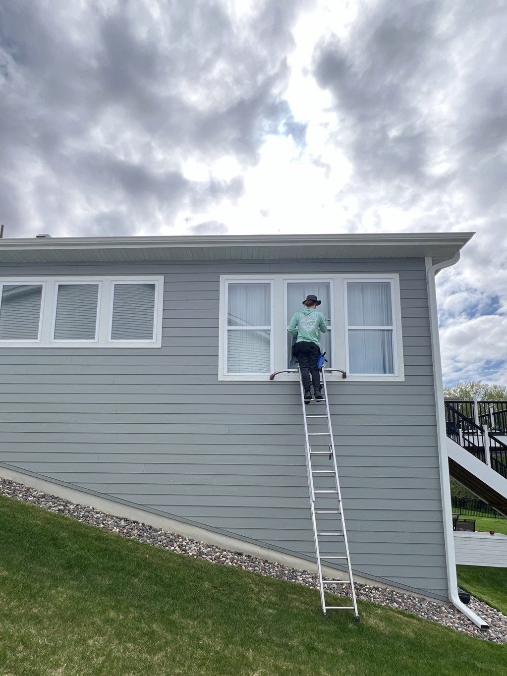 Window cleaner on a ladder cleaning residential windows
